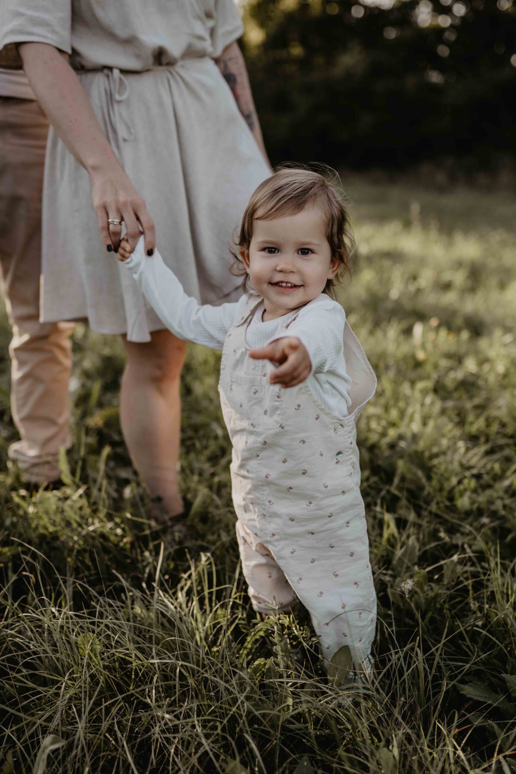 Das Kind grinst bei dem Fotoshooting in Mödling, in der Umgebung von Wien in die Kamera und zeigt mit dem Zeigefinger in die Richtung der Kamera