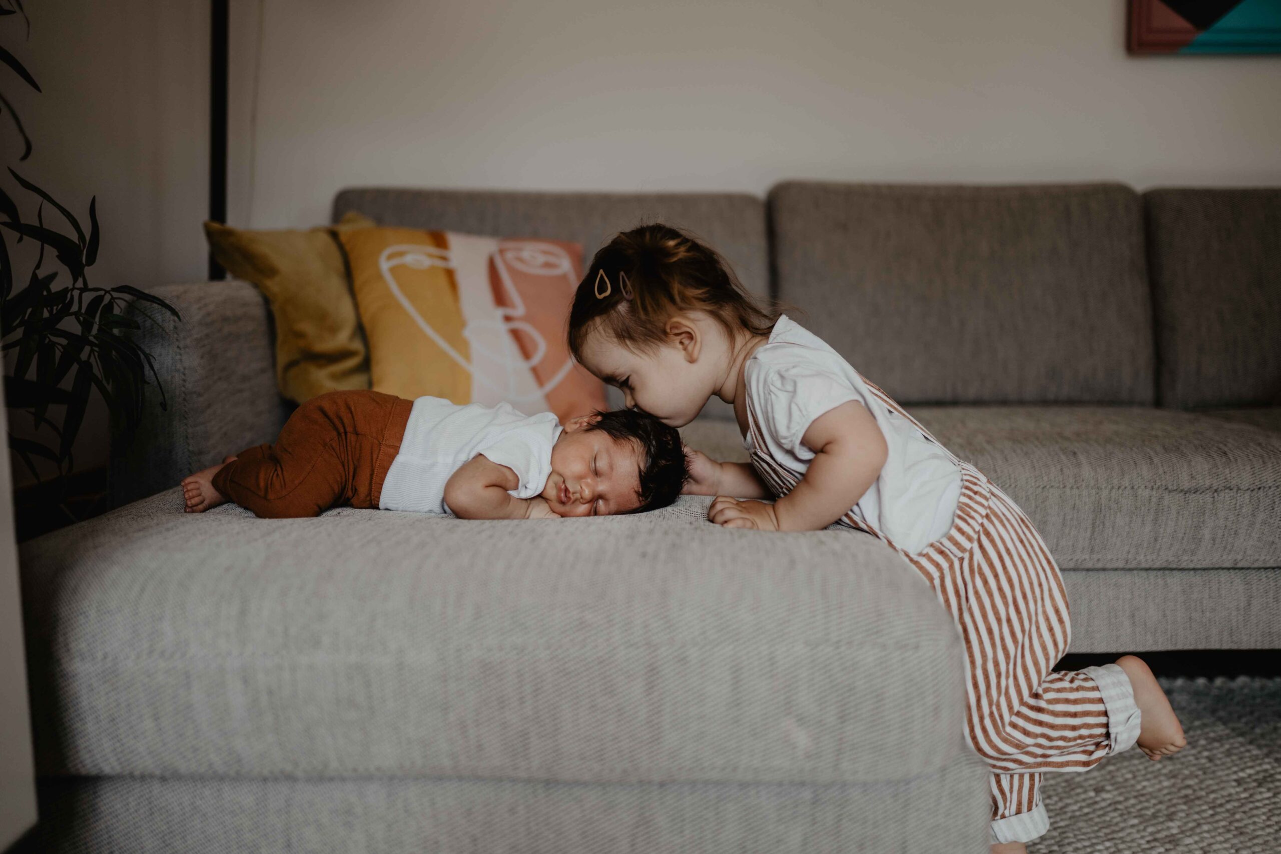 Die kleine Ida gibt ihrem Bruder bei dem Babyshooting ein Bussi auf den Kopf