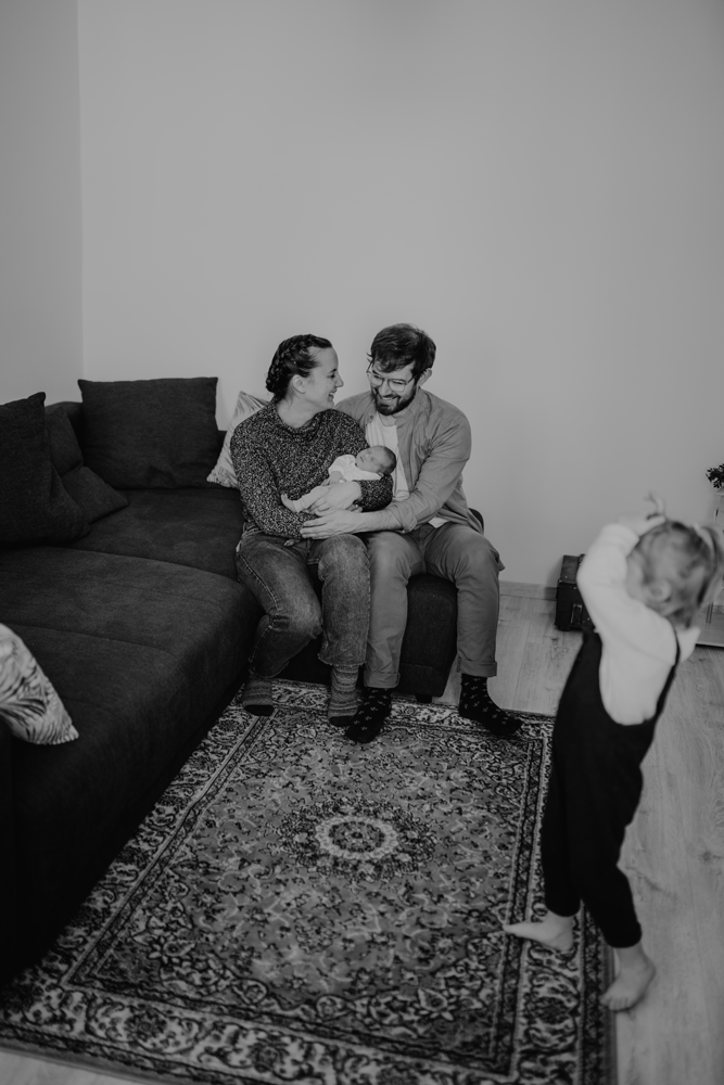 Ein Gif zeigt ein 3 jähriges Mädchen, das sich lachend im Kreis dreht. Mama und Papa halten im Hintergrund das Baby. Es entstehen gerade Babyfotos in Wien.