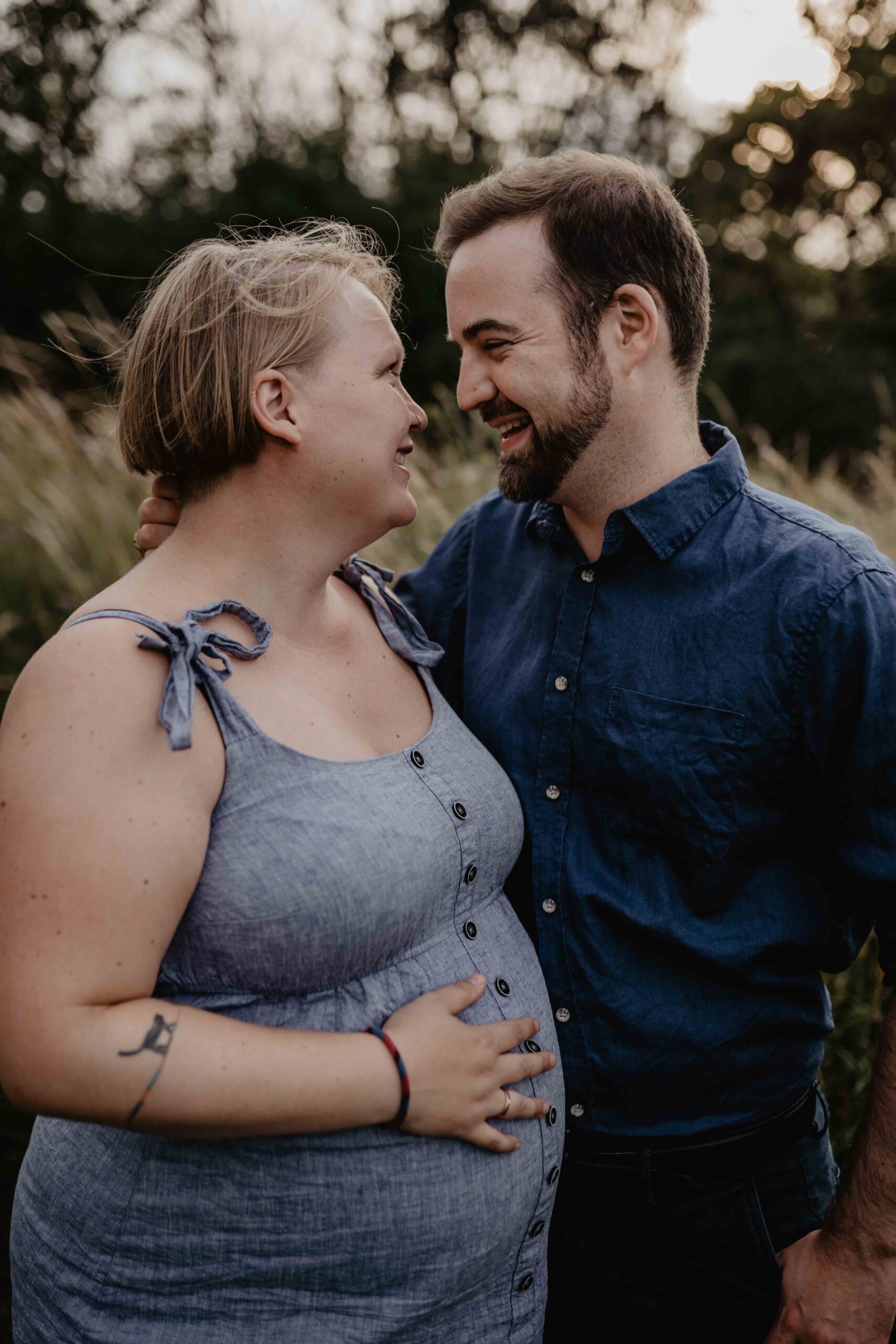 Bei einem Babybauchfotoshooting strahlt die schwangere Frau ihren Mann an. Franziska Bittermann, eine Babybauchfotografin hält diese besonderen Momente fest.