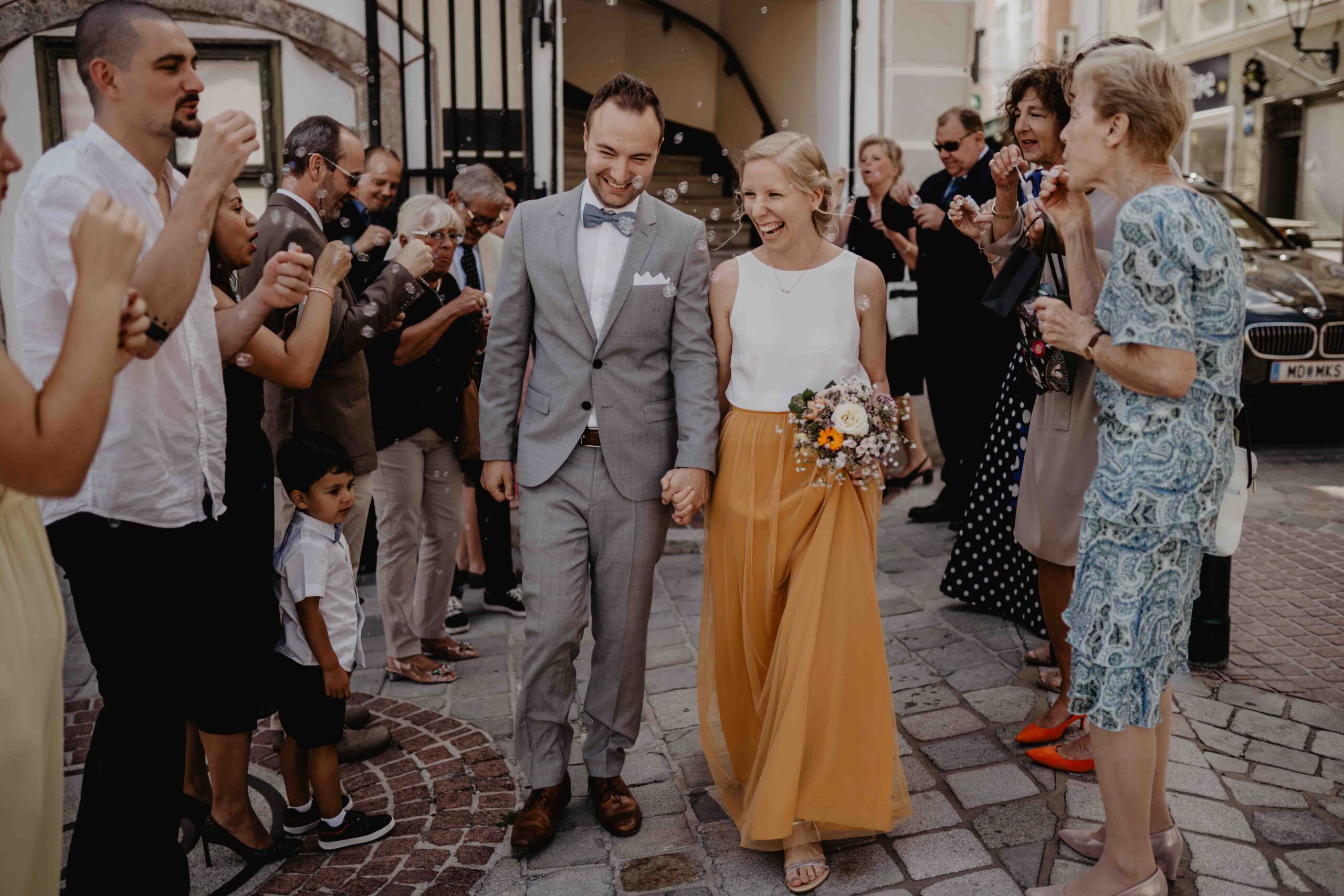 Ein Hochzeitspaar spaziert frisch verheiratet und glücklich aus dem Standesamt in Mödling. Eine Hochzeitsfotografin hält diese Momente für das frische Ehepaar fest.