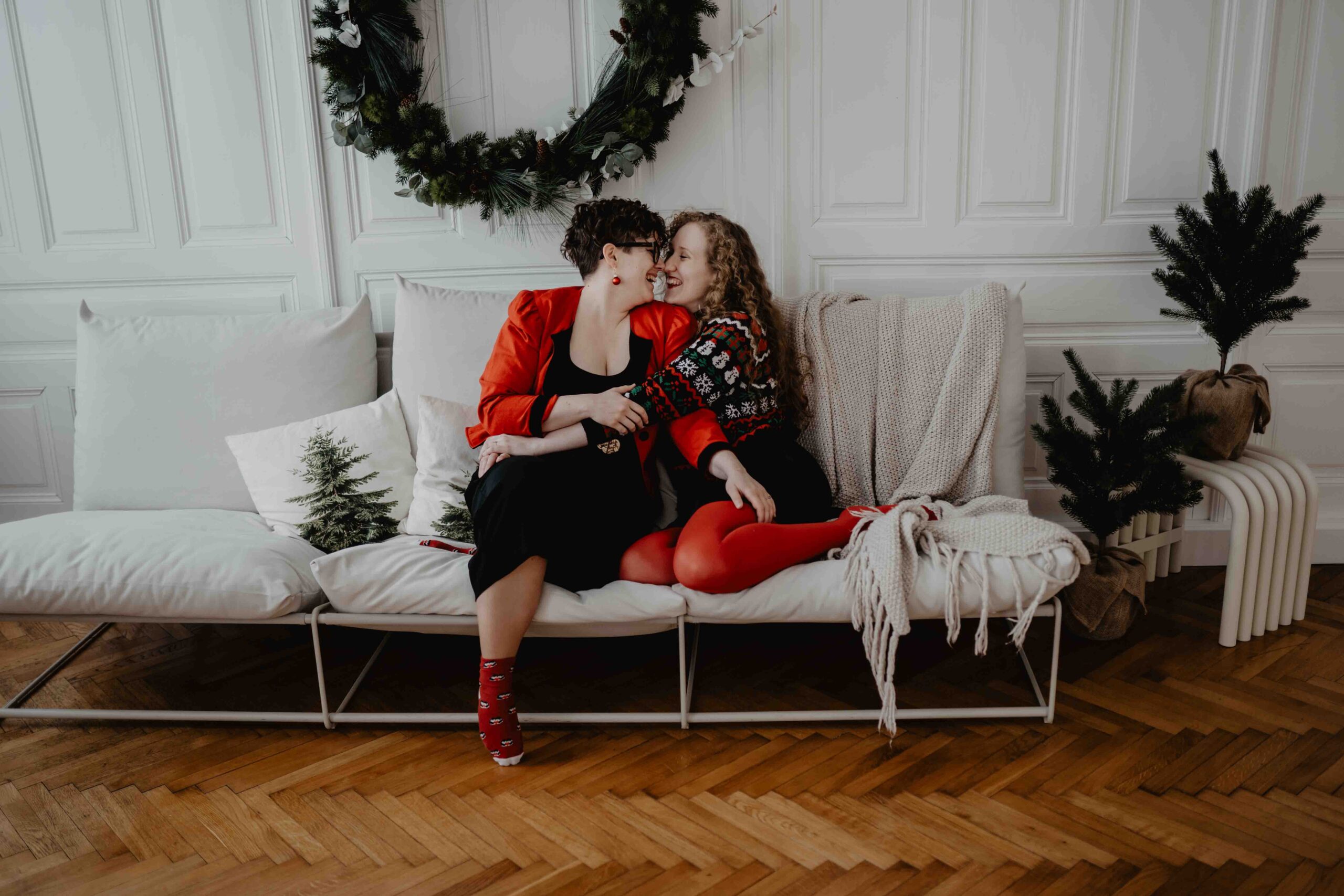 Ein Paar kuschelt sich bei einem Weihnachtsminishooting in Wien auf der Couch ganz nah zueinander.