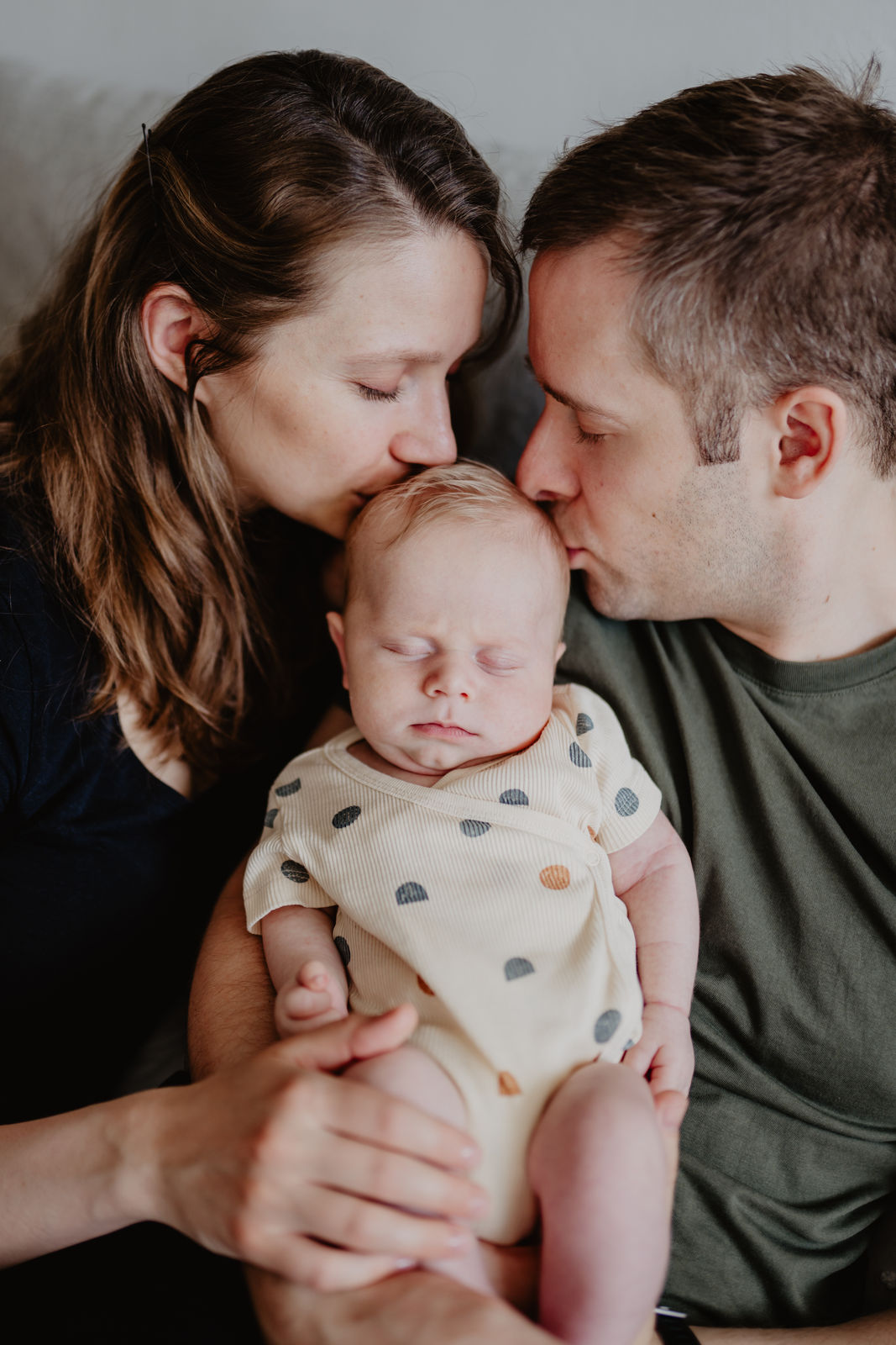 natürliche Babyfotos in Mödling - Mama und Papa geben ihrem Baby ein Bussi auf den Kopf