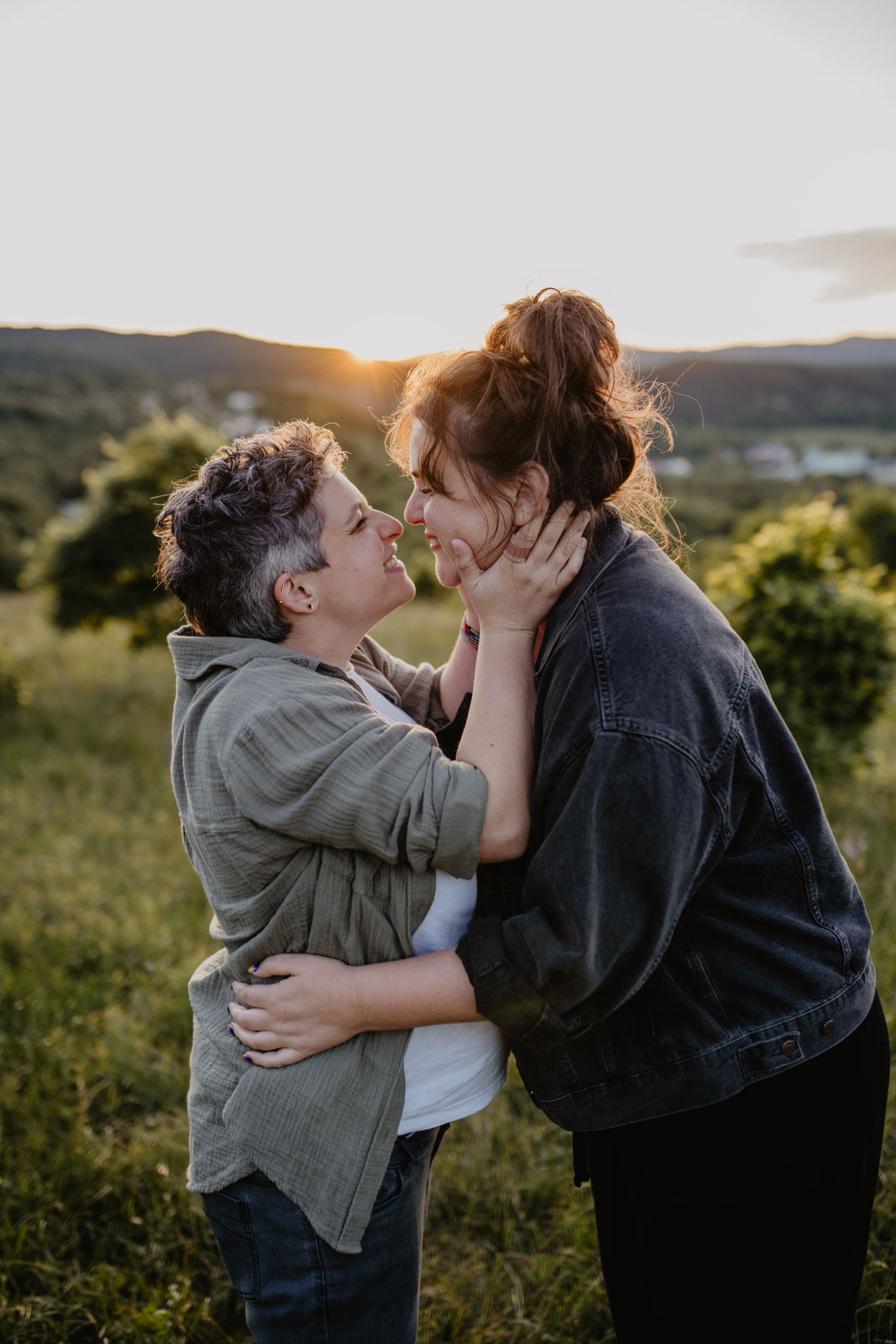 Zwei Frauen sind sich ganz nahe und lachen bei Babybauchfotos in Niederoesterreich